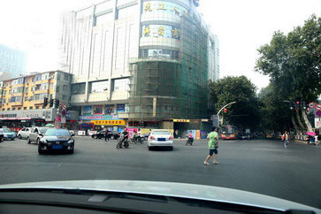 如图所示，驾驶机动车通过这样的路口时，应注意行人、非机动车，提前减速随时准备停车避让。配图