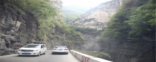 如图所示，驾驶机动车在这样的路段遇前方两车交会应及时减速。配图